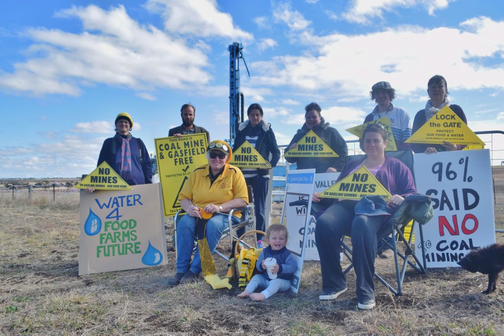Southern Downs Protection Group members and residents Sarah Moles, Duncan Burnet, Marianne Irvine, Mandy Mutch, Taryn Turl, Fiona Gray, Lachlan Trimingham and Michelle Amos protest in front of the coal drilling rig at Mt Marshall. 
